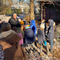 Volkmar Johannes "John" Schneider-Merck zeigt den Schulkindern das alte Kutscherhaus der Amsincks